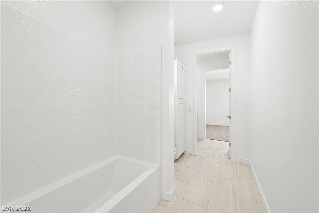 Crisp subway tile surrounds a built-in tub in this bright bathroom.