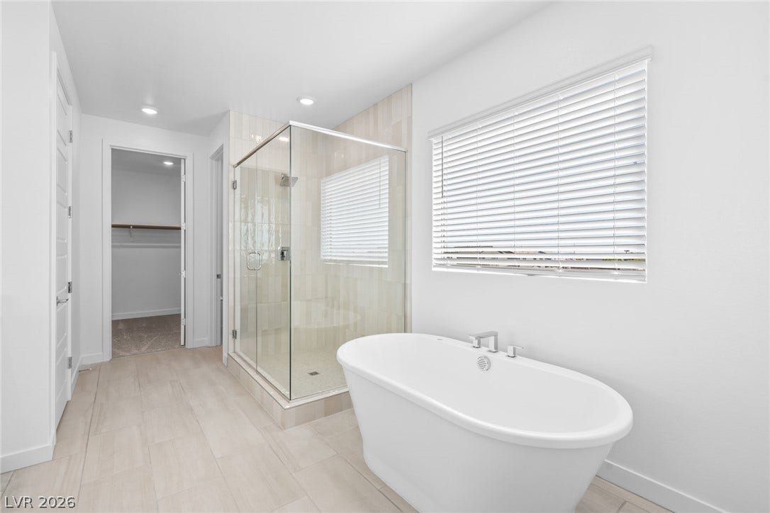 A glass-enclosed walk-in shower and freestanding tub elevate this serene bathroom layout.