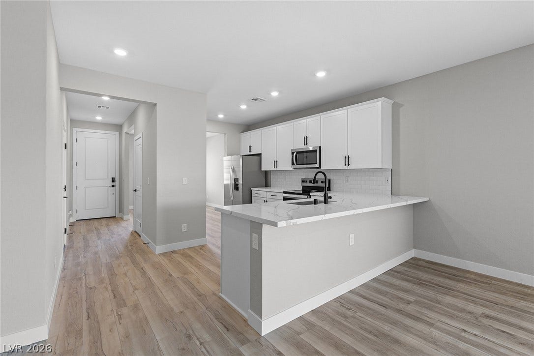 4460 Cave Lake Avenue, North Las Vegas, NV 89032 An open floor plan connects the sleek modern kitchen directly to the dining area.