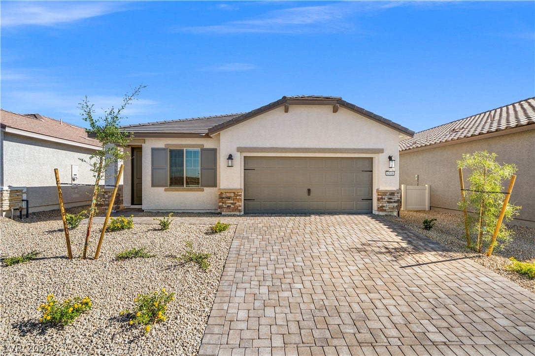 4460 Cave Lake Avenue, North Las Vegas, NV 89032 An elegant paver driveway leads to a modern stucco home with desert-friendly landscaping.