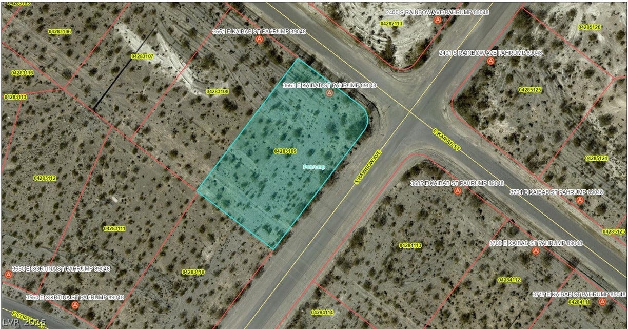 An aerial plat map outlines this spacious corner desert lot highlighted in blue.