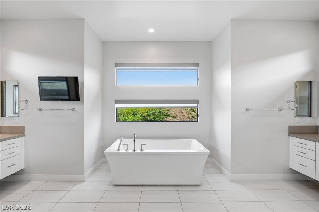 1 Moonfire Drive, Las Vegas, NV 89135 Symmetrical architectural lines frame a freestanding soaking tub situated between dual vanities.