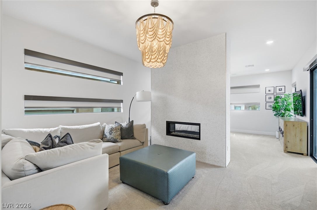 1 Moonfire Drive, Las Vegas, NV 89135 A modern double-sided fireplace acts as a central architectural feature in this open living space.