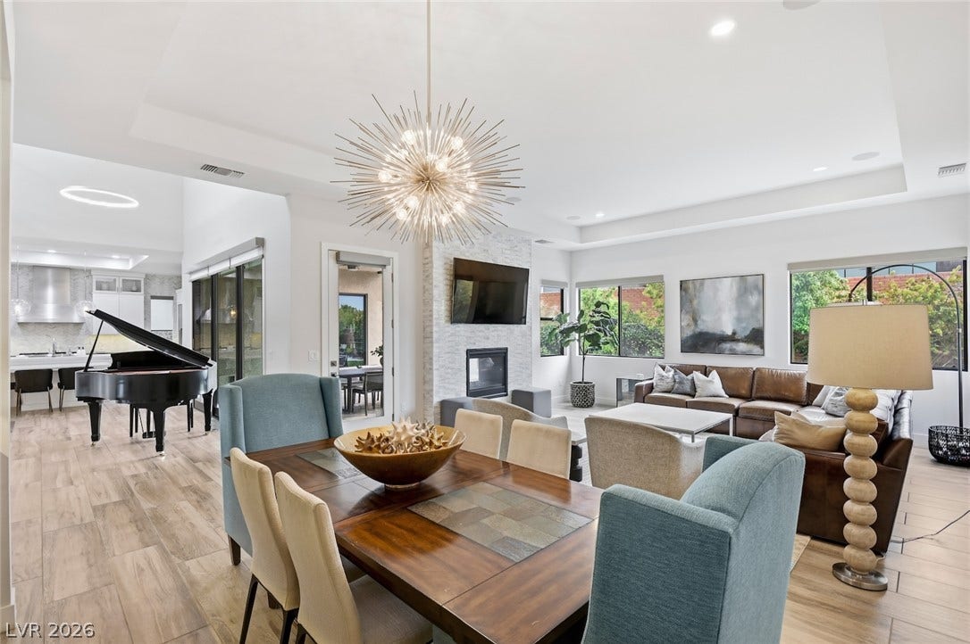 1 Moonfire Drive, Las Vegas, NV 89135 Gleaming wood-look tile floors and elegant tray ceilings define this expansive open-concept living space.