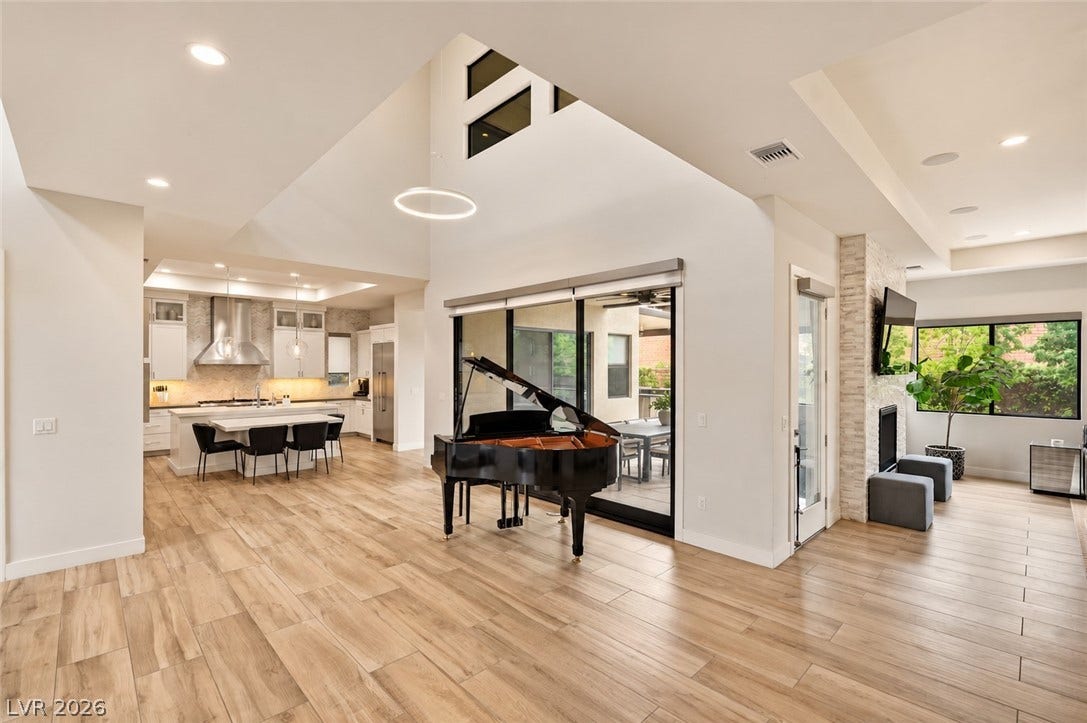 1 Moonfire Drive, Las Vegas, NV 89135 Soaring vaulted ceilings and rich wood-look flooring define this open, light-filled living space.