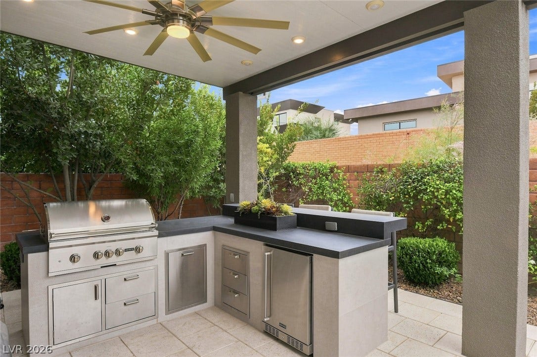 1 Moonfire Drive, Las Vegas, NV 89135 An outdoor kitchen features premium stone countertops and a built-in grill under a covered patio.