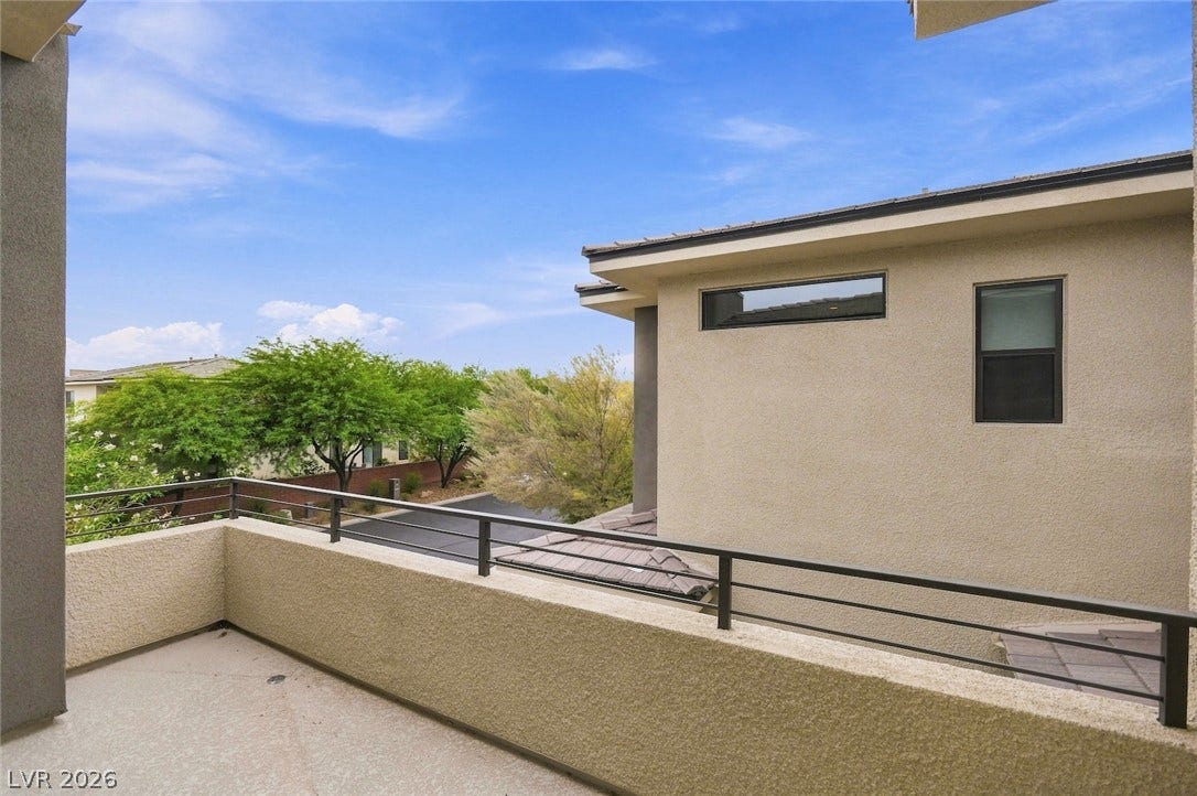1 Moonfire Drive, Las Vegas, NV 89135 A spacious concrete balcony features strong linear metal railings set against a stucco exterior.