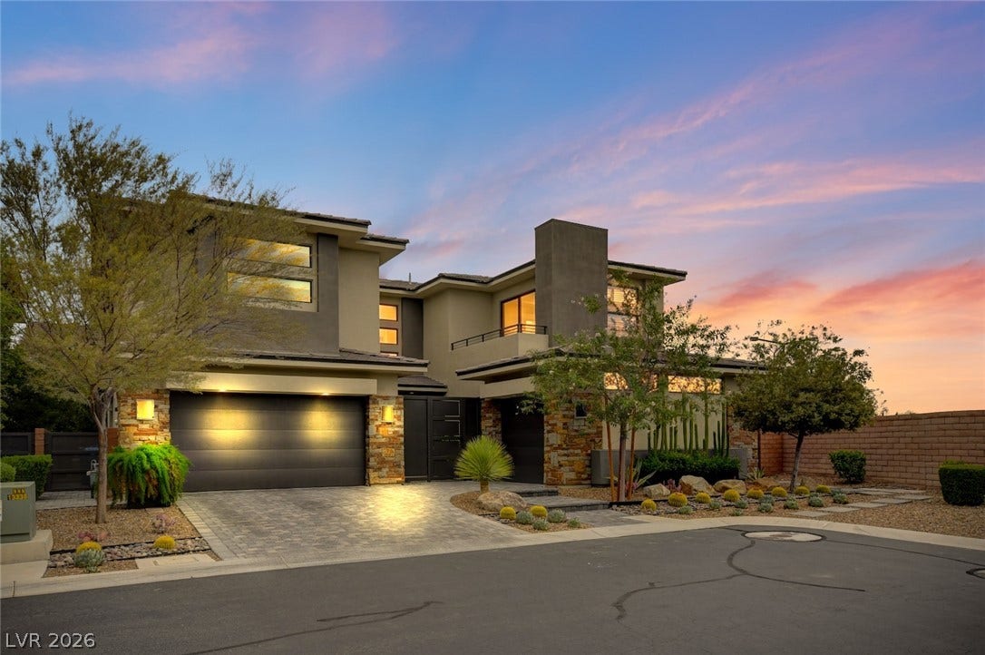 1 Moonfire Drive, Las Vegas, NV 89135 Striking contemporary architecture showcases clean geometric lines and a multi-car garage under a twilight sky.