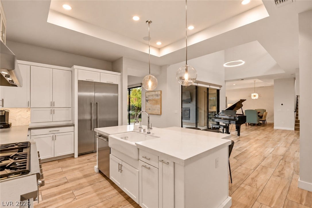 1 Moonfire Drive, Las Vegas, NV 89135 An open kitchen layout features clean lines, tray ceilings, and handsome wood-look flooring.