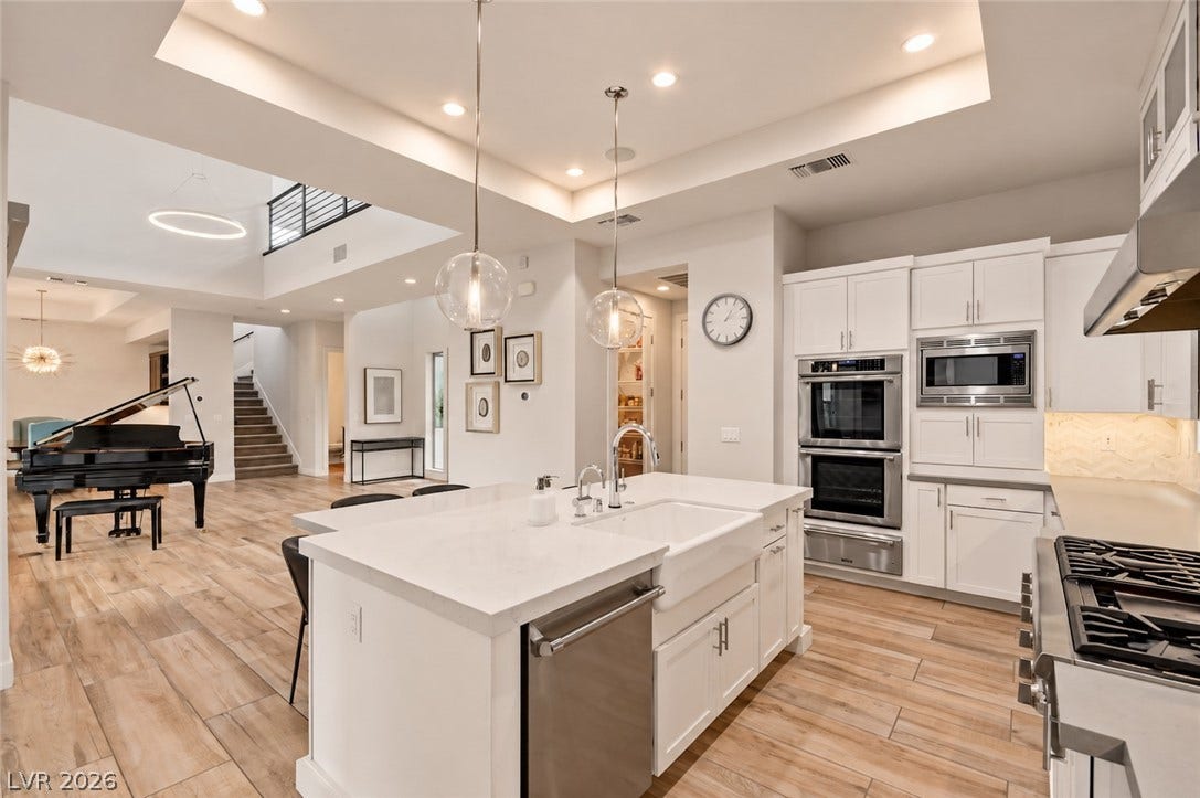 1 Moonfire Drive, Las Vegas, NV 89135 Recessed lighting and warm wood-look tile flooring anchor this expansive open kitchen and living space.