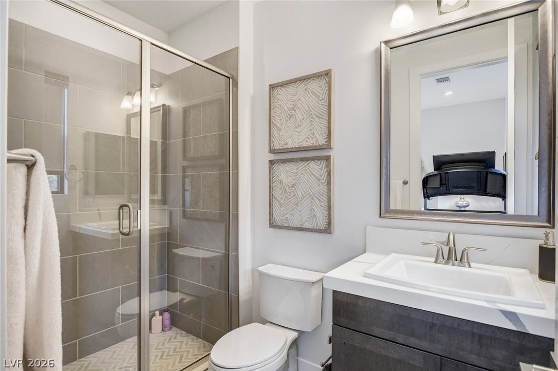1 Moonfire Drive, Las Vegas, NV 89135 Modern stone counters and a sleek glass shower define this contemporary bathroom.