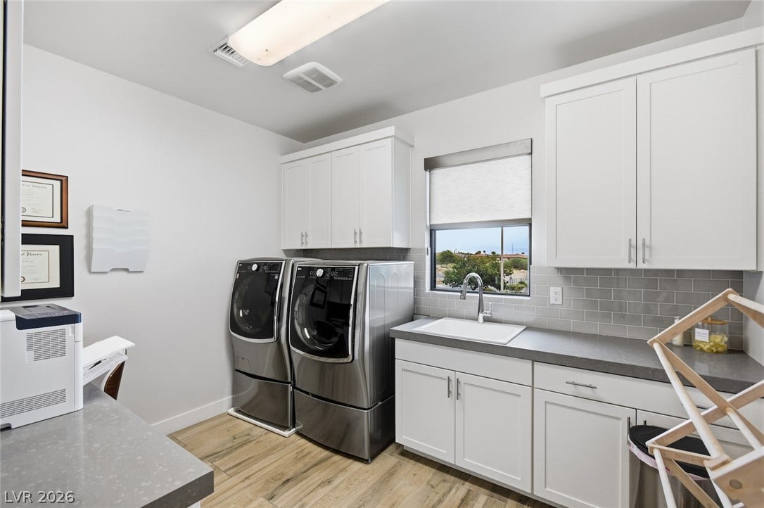 1 Moonfire Drive, Las Vegas, NV 89135 Gleaming wood-look floors complement modern cabinetry and solid surface countertops in this functional utility space.