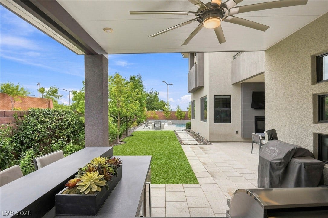 1 Moonfire Drive, Las Vegas, NV 89135 An inviting covered patio steps down to a paved terrace and grassy lawn.
