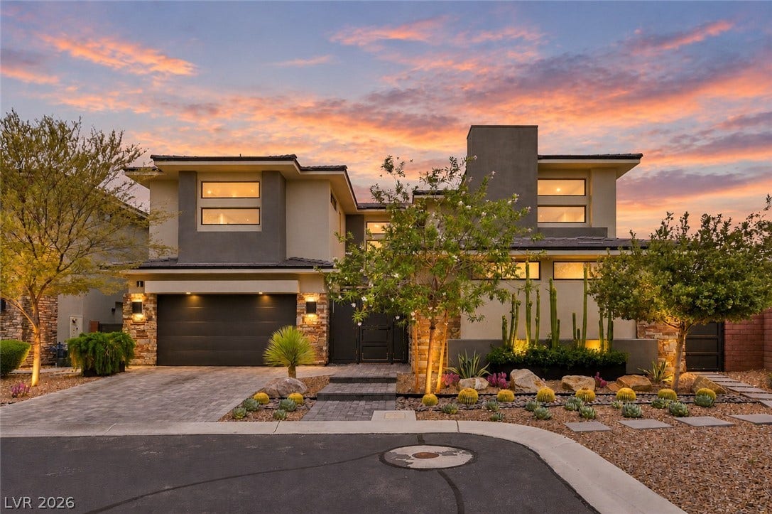 1 Moonfire Drive, Las Vegas, NV 89135 Striking contemporary architecture meets manicured desert landscaping under a dramatic evening sky.