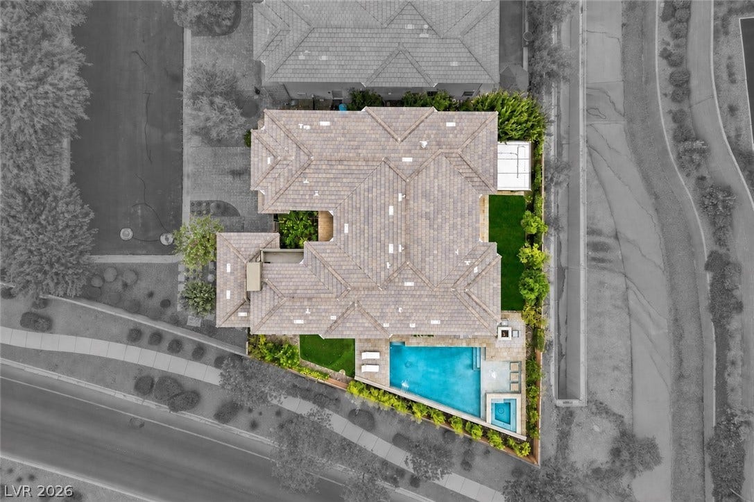 1 Moonfire Drive, Las Vegas, NV 89135 An aerial perspective showcases a tiled roof, manicured lawn, and a custom swimming pool.