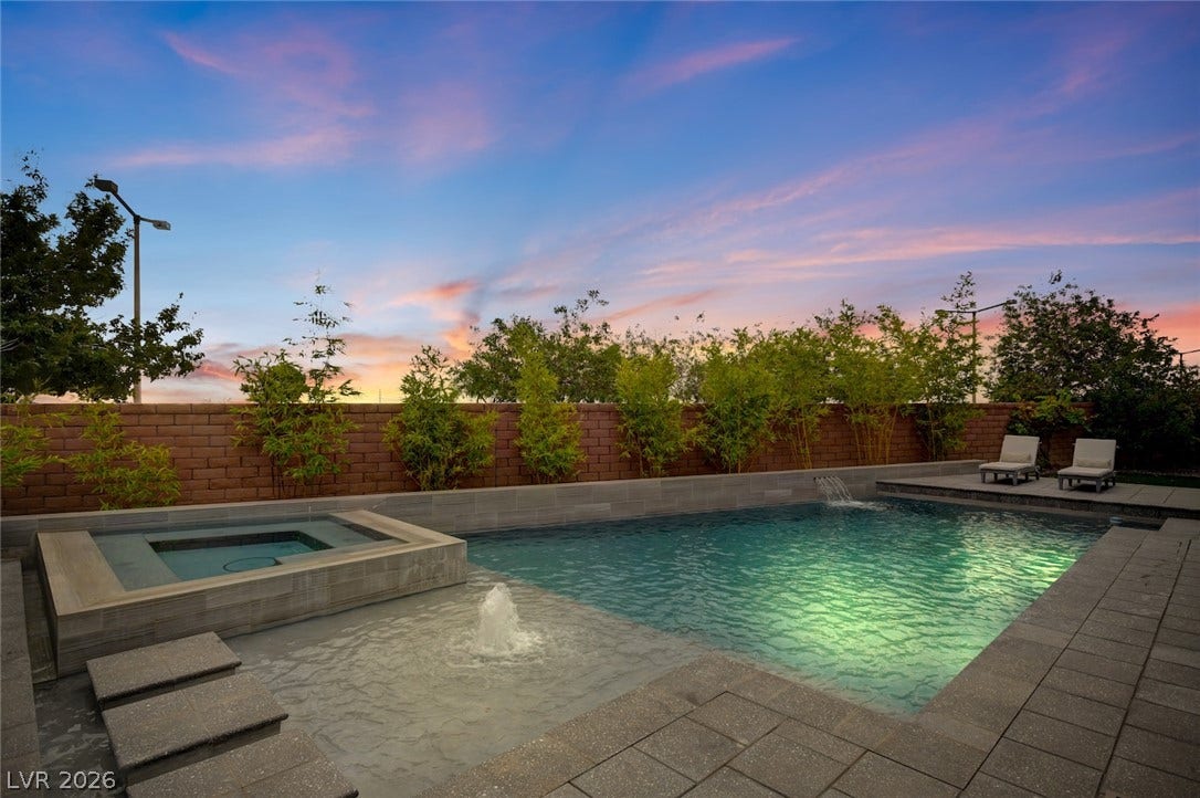 1 Moonfire Drive, Las Vegas, NV 89135 An inviting swimming pool and spa are set against a backdrop of mature greenery.