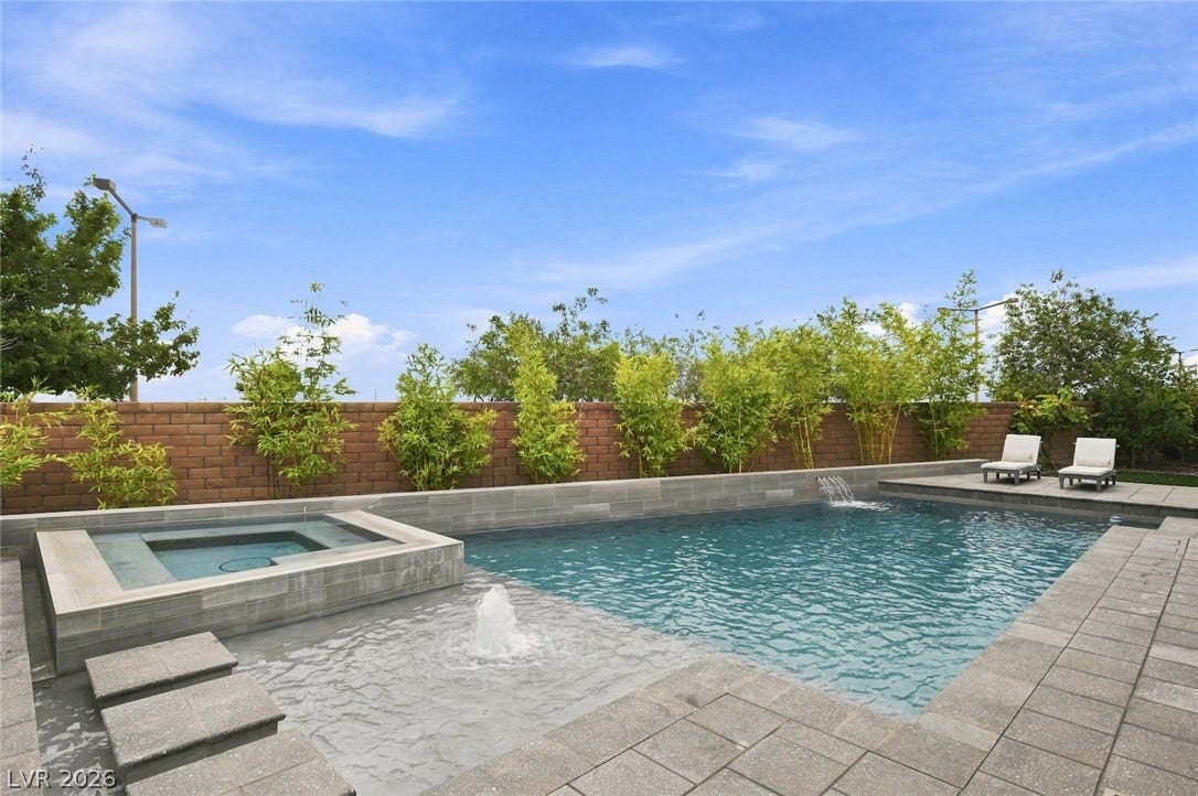 1 Moonfire Drive, Las Vegas, NV 89135 An inviting backyard oasis features a modern swimming pool bordered by a stone block wall.
