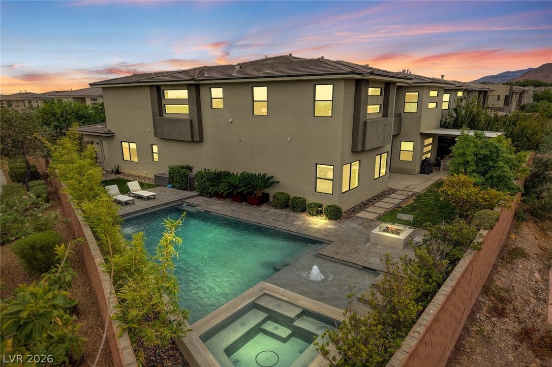 1 Moonfire Drive, Las Vegas, NV 89135 An inviting backyard oasis centers around a pristine swimming pool beneath a twilight sky.