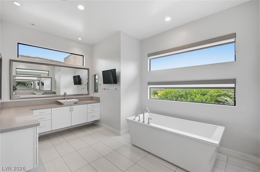 1 Moonfire Drive, Las Vegas, NV 89135 High ceilings and clean tiled flooring complement a deep soaking tub and sleek modern vanity.