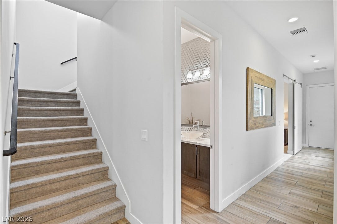 1 Moonfire Drive, Las Vegas, NV 89135 Smooth wood-look tile flooring and clean white walls line this modern, light-filled hallway.