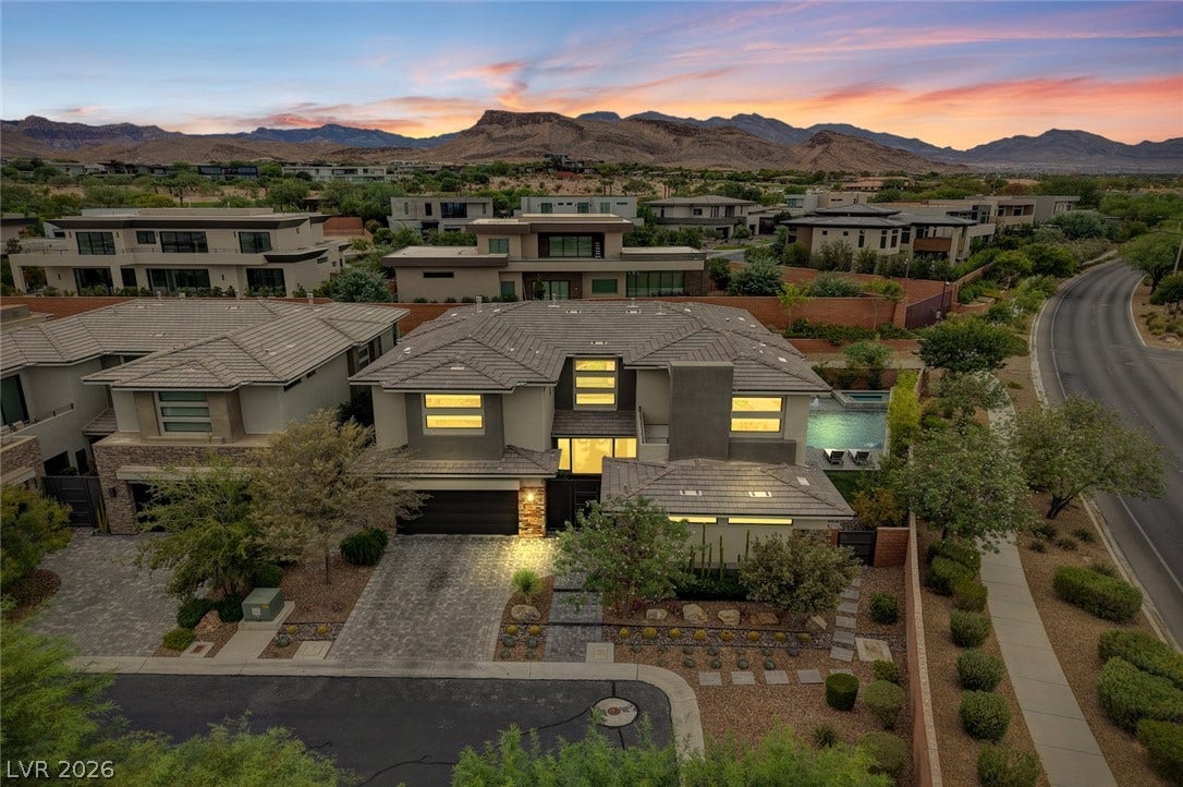1 Moonfire Drive, Las Vegas, NV 89135 Dramatic mountain ridges frame a contemporary neighborhood of custom estates under sunset skies.