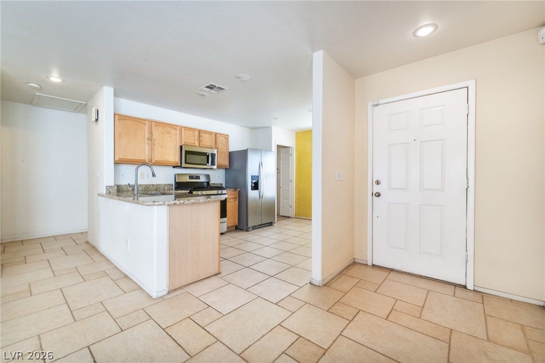 769 Salt Flats Circle, Henderson, NV 89011 Tiled flooring flows from the entry into an open kitchen with stone countertops.