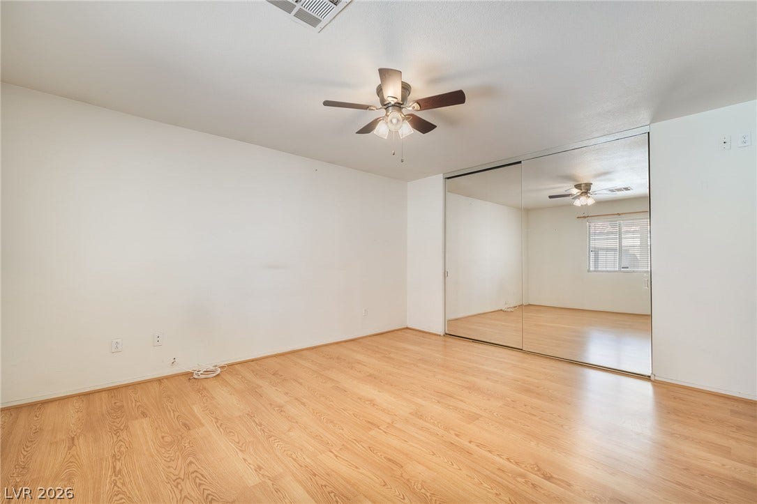 769 Salt Flats Circle, Henderson, NV 89011 Warm wood flooring and sliding mirrored closet doors define this functional bedroom space.