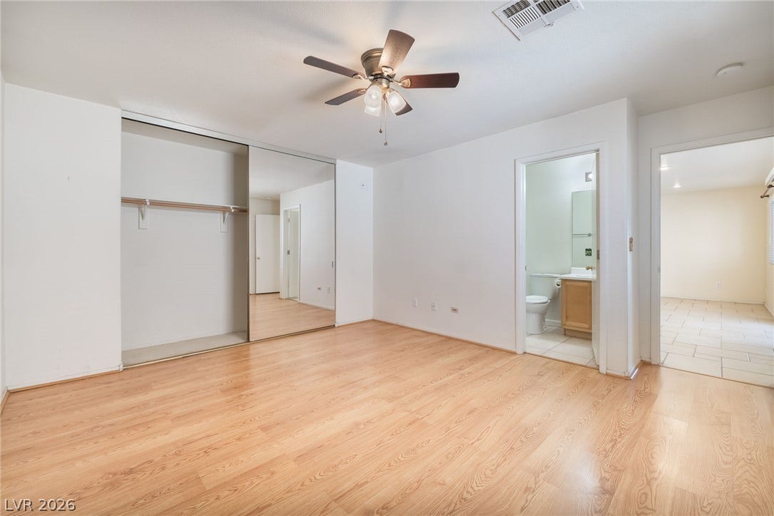 769 Salt Flats Circle, Henderson, NV 89011 Warm wood flooring and mirrored closet doors define this functional bedroom space.