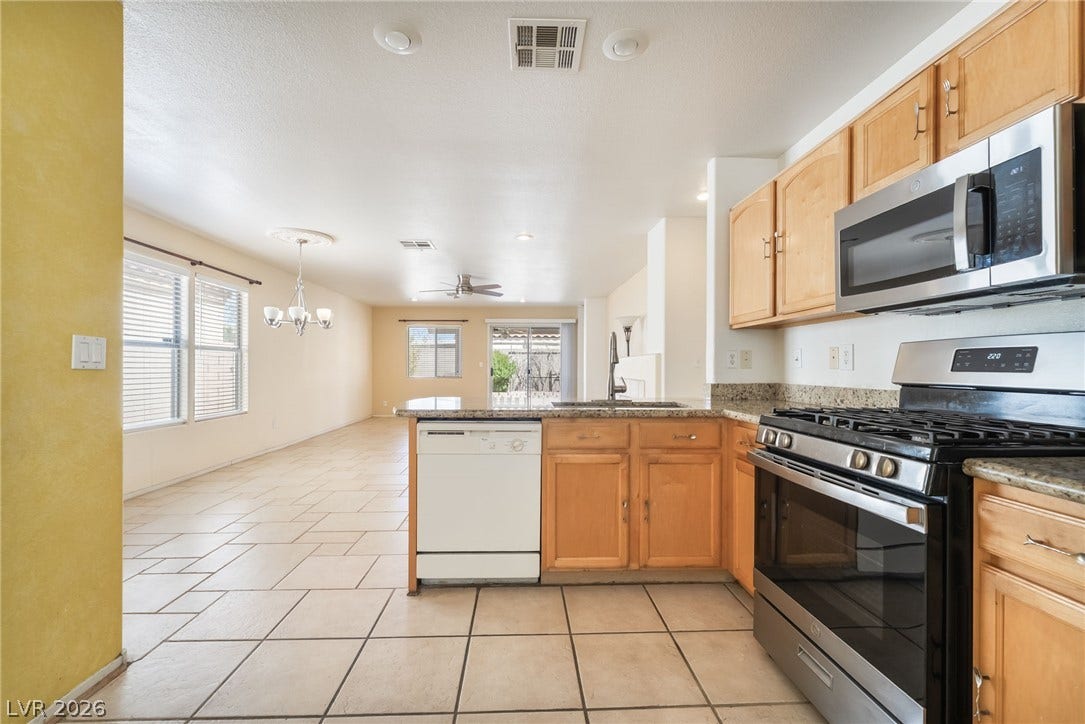 769 Salt Flats Circle, Henderson, NV 89011 Granite counters and tiled flooring anchor this bright, open kitchen flowing into the living area.