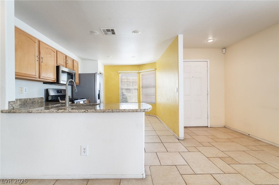 769 Salt Flats Circle, Henderson, NV 89011 Granite countertops and tile flooring create an inviting transition from kitchen to entryway.