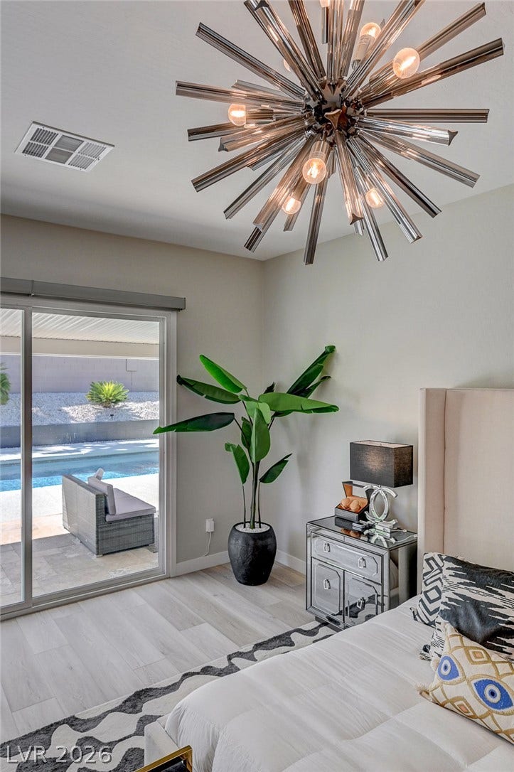2689 Pioneer Estates Court, Las Vegas, NV 89117 Glass sliding doors offer a seamless transition from the sleek bedroom to the pool area.