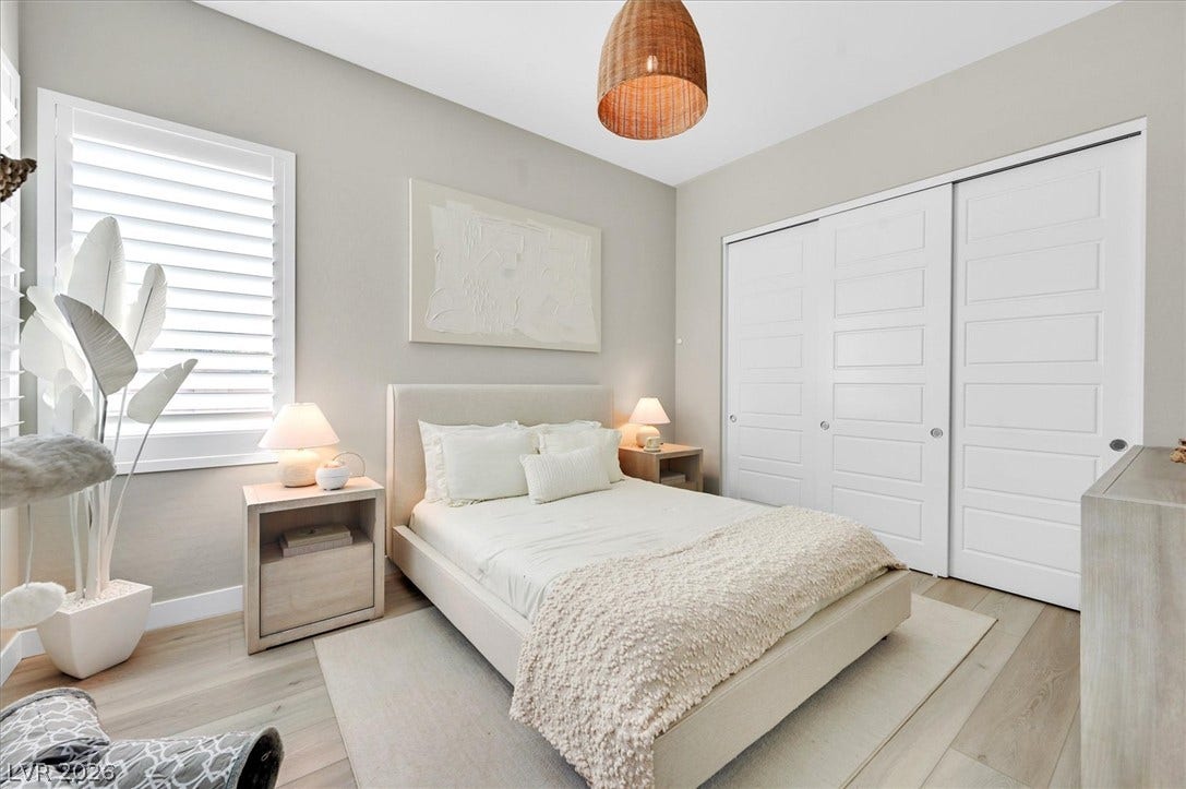 2689 Pioneer Estates Court, Las Vegas, NV 89117 A quiet bedroom features light wood floors and large closet doors under high ceilings.