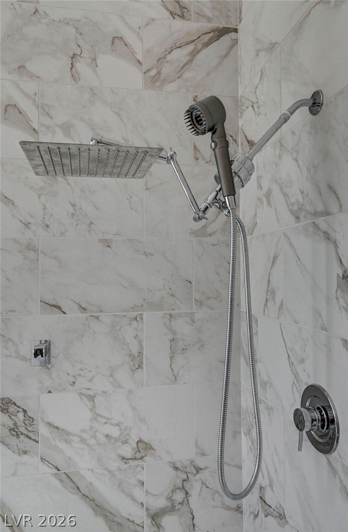 2689 Pioneer Estates Court, Las Vegas, NV 89117 Elegantly veined marble tiling lines the walls of this custom walk-in shower enclosure.