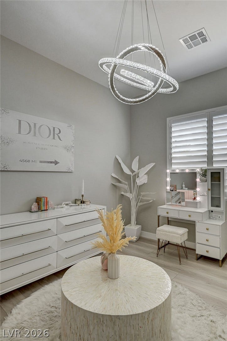 2689 Pioneer Estates Court, Las Vegas, NV 89117 High ceilings and plantation shutters accent this light-filled room with wood-style flooring.