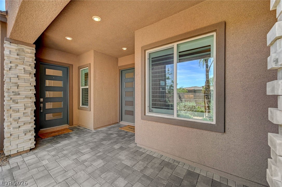 2689 Pioneer Estates Court, Las Vegas, NV 89117 Welcoming covered front porch featuring textured stucco walls, stone accents, and clean modern doors.