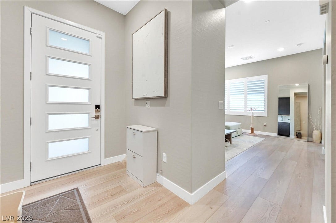 2689 Pioneer Estates Court, Las Vegas, NV 89117 An inviting entryway transitions smoothly into a modern open floorplan with recessed lighting and neutral wood floors.