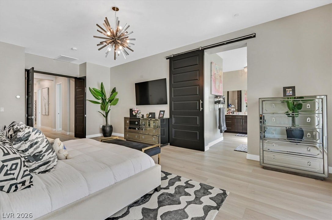 2689 Pioneer Estates Court, Las Vegas, NV 89117 Hardwood floors and a custom sliding barn door define this spacious master bedroom suite.