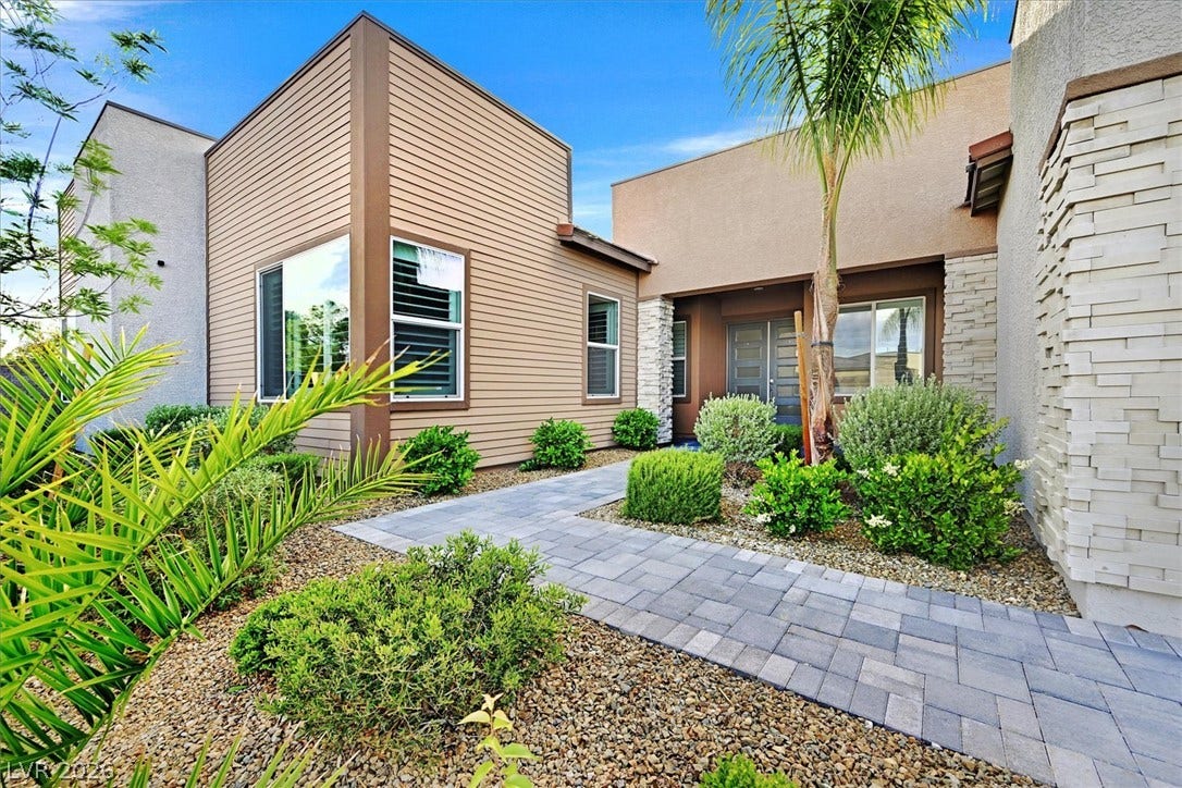 2689 Pioneer Estates Court, Las Vegas, NV 89117 A paved stone pathway guides visitors toward the entrance of this contemporary multi-textured exterior.