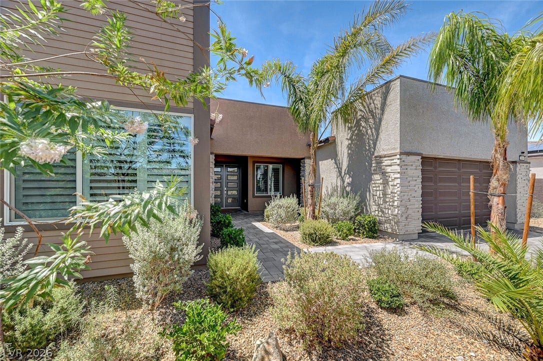 2689 Pioneer Estates Court, Las Vegas, NV 89117 Lush landscaping and desert-inspired stone accents frame a welcoming contemporary entry.