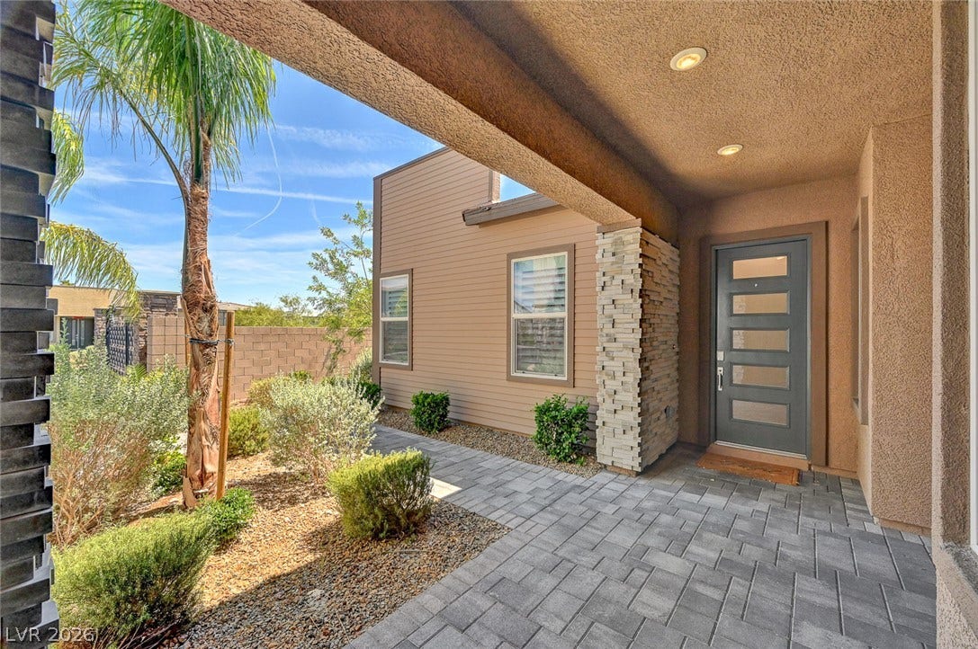 2689 Pioneer Estates Court, Las Vegas, NV 89117 A modern paved entryway transitions smoothly into desert landscaping under a covered porch ceiling.