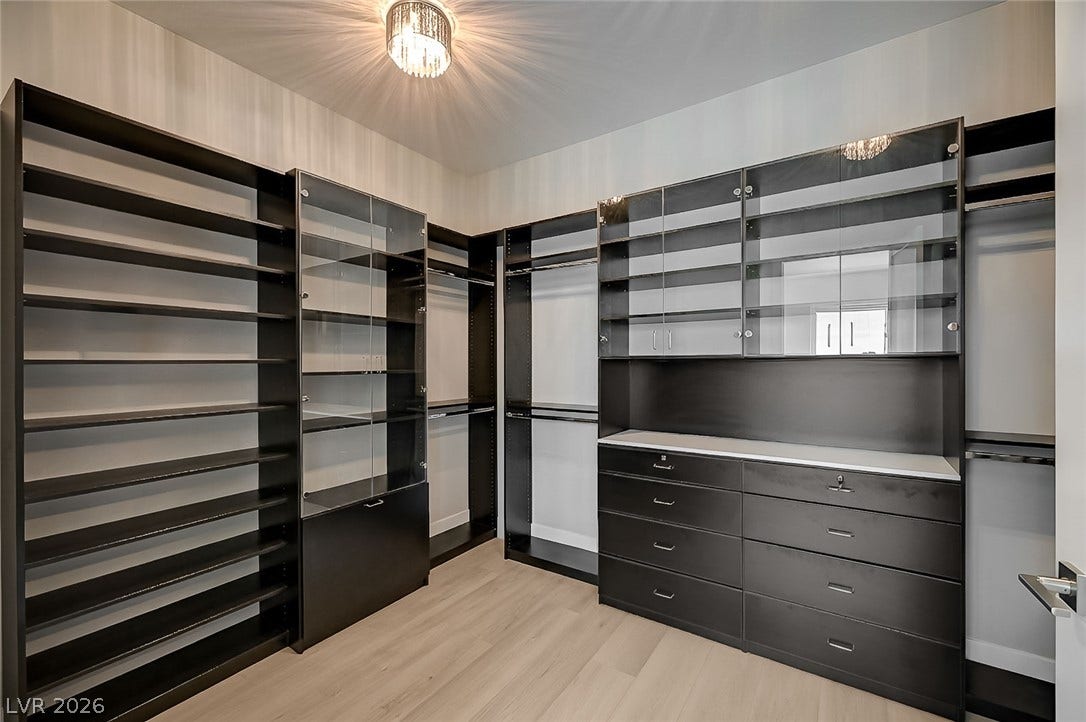 2689 Pioneer Estates Court, Las Vegas, NV 89117 Custom built-in cabinetry and light hardwood flooring define this organized walk-in closet.