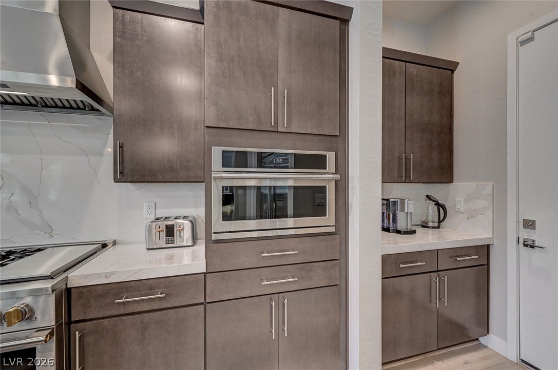 2689 Pioneer Estates Court, Las Vegas, NV 89117 Streamlined flat-panel cabinetry and stone countertops elevate this modern cooking space.
