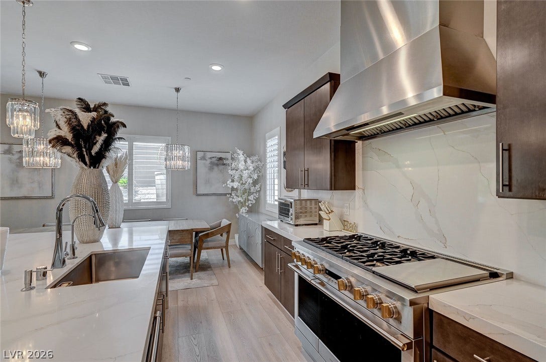 2689 Pioneer Estates Court, Las Vegas, NV 89117 Polished stone counters and premium stainless steel appliances anchor this open-concept culinary space.