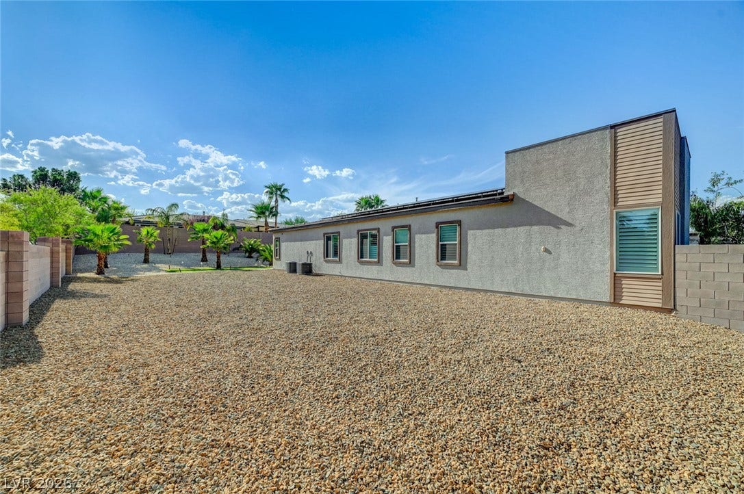2689 Pioneer Estates Court, Las Vegas, NV 89117 Low-maintenance gravel landscaping surrounds this modern stucco home under blue skies.