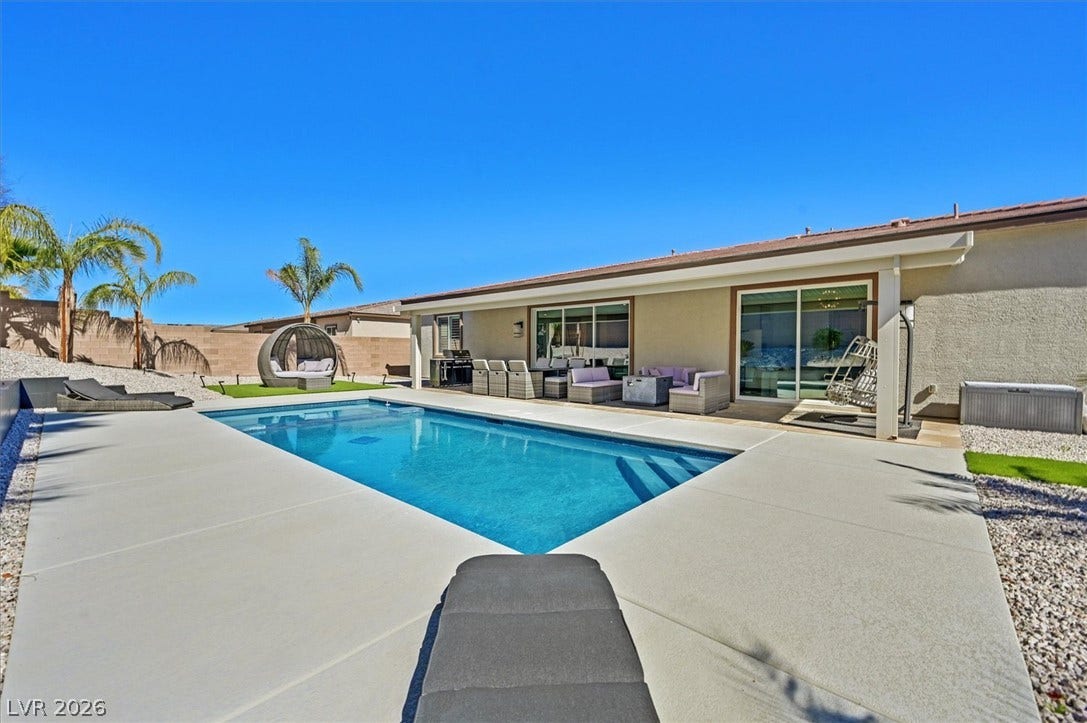 2689 Pioneer Estates Court, Las Vegas, NV 89117 An inviting backyard oasis showcases a sparkling swimming pool, spacious concrete patio, and covered porch.
