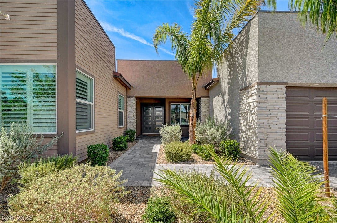 2689 Pioneer Estates Court, Las Vegas, NV 89117 A paved walkway leads past desert landscaping to the modern double-door entrance.
