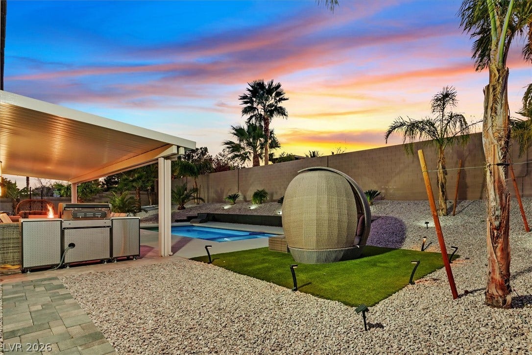 2689 Pioneer Estates Court, Las Vegas, NV 89117 An inviting backyard oasis features a covered patio, outdoor kitchen, and sparkling swimming pool.