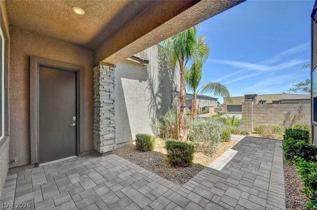 2689 Pioneer Estates Court, Las Vegas, NV 89117 Stone pavers frame the welcoming entrance hallway leading past desert plantings and a structured stone column.