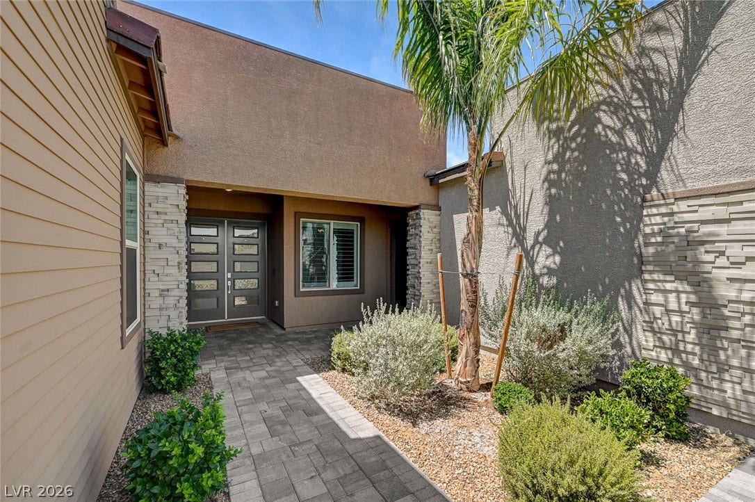 2689 Pioneer Estates Court, Las Vegas, NV 89117 An inviting stone-paved walkway leads to double entry doors framed by modern mixed-siding architecture.
