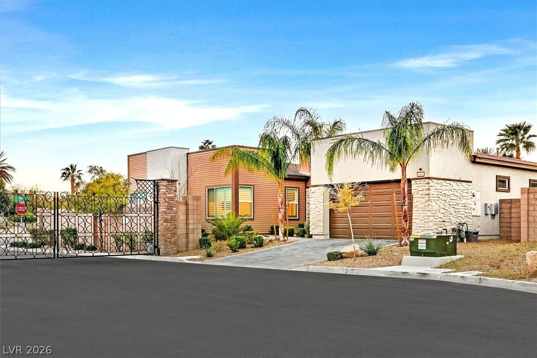 2689 Pioneer Estates Court, Las Vegas, NV 89117 Modern desert architecture stands behind a secure gated entrance under wide blue skies.